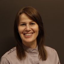 Kvinne med brunt hår og lys bluse